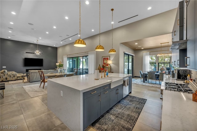 kitchen with pendant lighting, light countertops, a sink, and light tile patterned floors