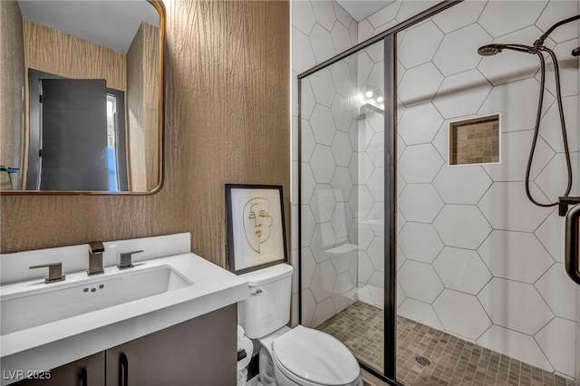 bathroom featuring wallpapered walls, a shower stall, toilet, and vanity