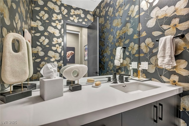 bathroom with wallpapered walls and vanity