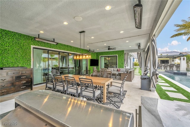 view of patio featuring a ceiling fan, outdoor dining space, an outdoor pool, and an outdoor hangout area