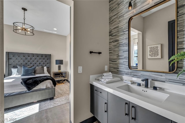 bathroom with concrete floors, vanity, decorative backsplash, and an inviting chandelier