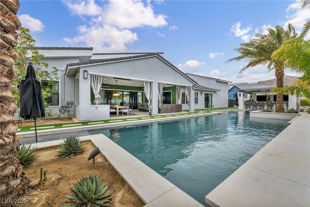 rear view of house featuring an outdoor pool, a patio area, an outdoor living space, and stucco siding