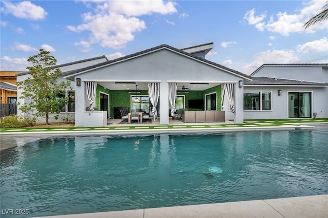 back of property with a fenced in pool, a patio, stucco siding, an outdoor hangout area, and ceiling fan