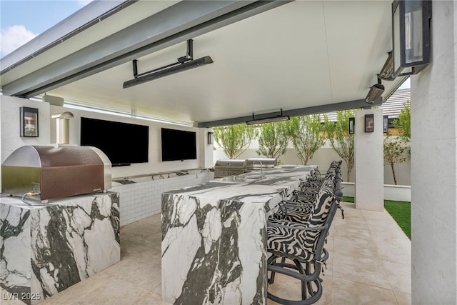 view of patio with outdoor wet bar and area for grilling