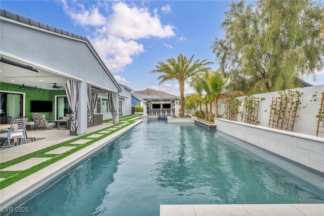 view of swimming pool featuring a patio area, a fenced backyard, a ceiling fan, and a fenced in pool