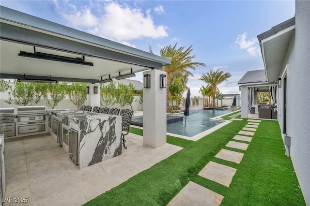 view of patio with area for grilling, fence, outdoor wet bar, and an outdoor pool