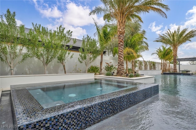 view of pool with an in ground hot tub and fence