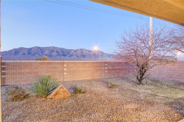 view of yard featuring a fenced backyard and a mountain view