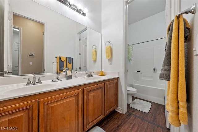 bathroom featuring a sink, shower / bathtub combination with curtain, toilet, and wood finished floors