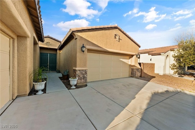 view of front of property with stone siding, a tile roof, driveway, and stucco siding