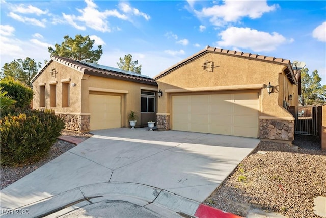 mediterranean / spanish-style house with stone siding, driveway, an attached garage, and stucco siding