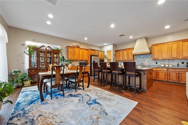 dining area with dark wood-type flooring, visible vents, and recessed lighting