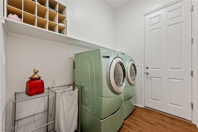 laundry room with laundry area, washing machine and dryer, and wood finished floors