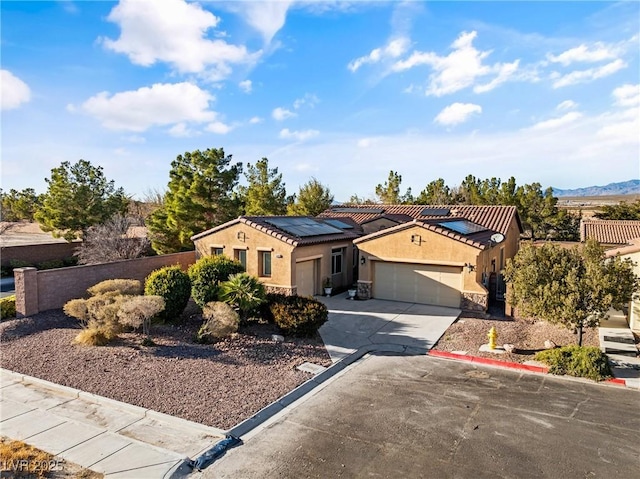 mediterranean / spanish-style house featuring a garage, fence, concrete driveway, and stucco siding