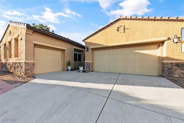 view of front of house with an attached garage, stone siding, driveway, and stucco siding