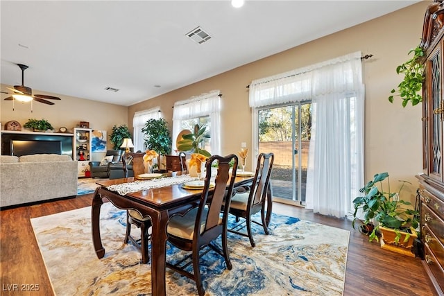 dining room with wood finished floors, visible vents, and a ceiling fan