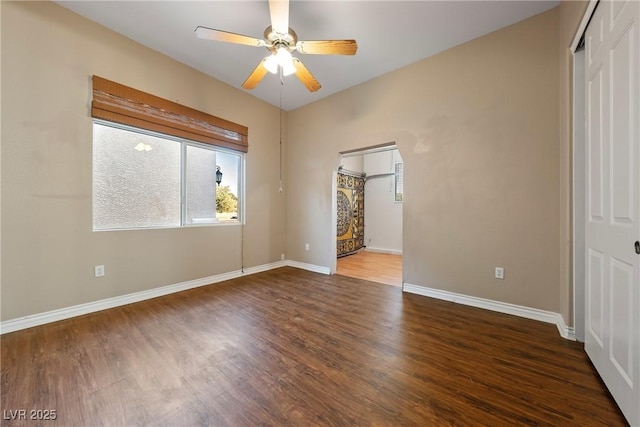 unfurnished room with a ceiling fan, baseboards, and wood finished floors