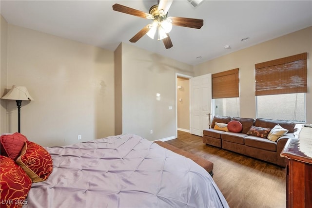 bedroom featuring visible vents, wood finished floors, a ceiling fan, and baseboards