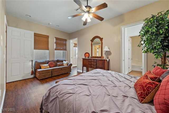 bedroom with a ceiling fan, connected bathroom, baseboards, and wood finished floors