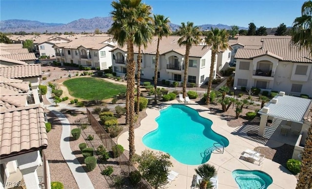 view of pool with a patio area, a residential view, and a mountain view