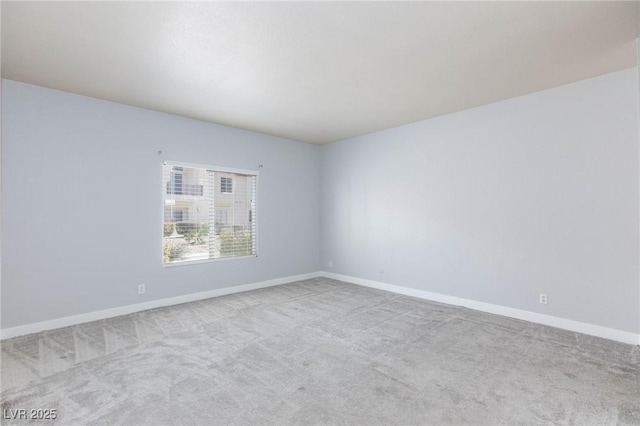 empty room with carpet and baseboards