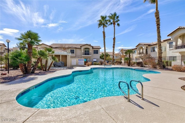 pool with a residential view, fence, and a patio