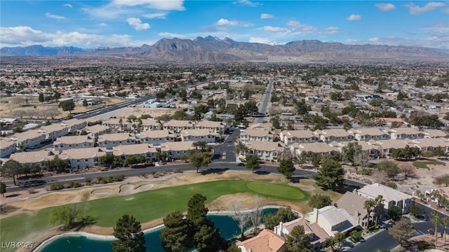 drone / aerial view with a residential view, a mountain view, and golf course view