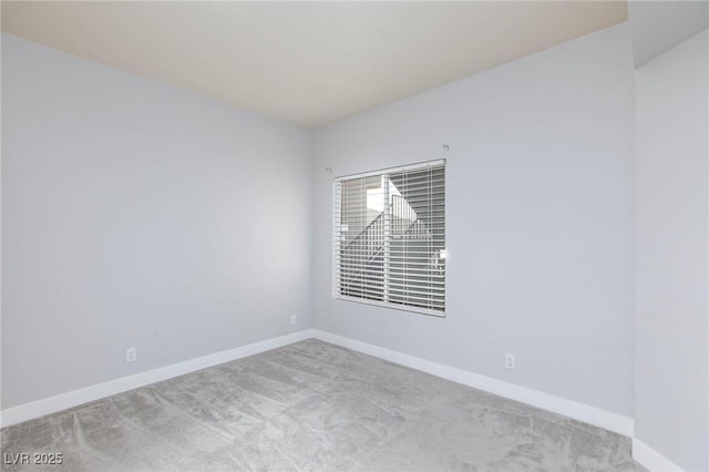 empty room featuring carpet floors and baseboards