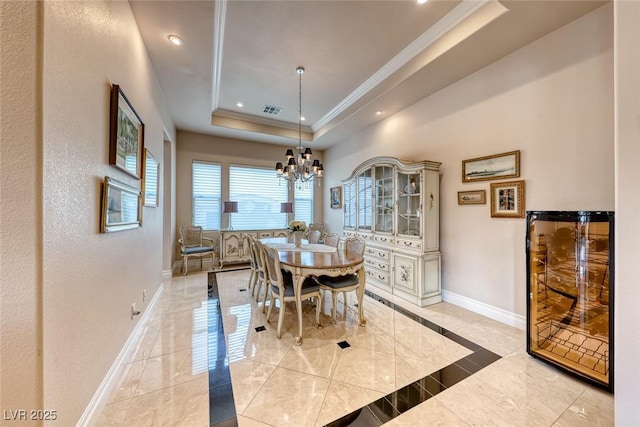 dining space featuring ornamental molding, a tray ceiling, visible vents, and baseboards