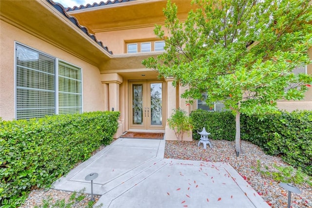 doorway to property featuring french doors and stucco siding