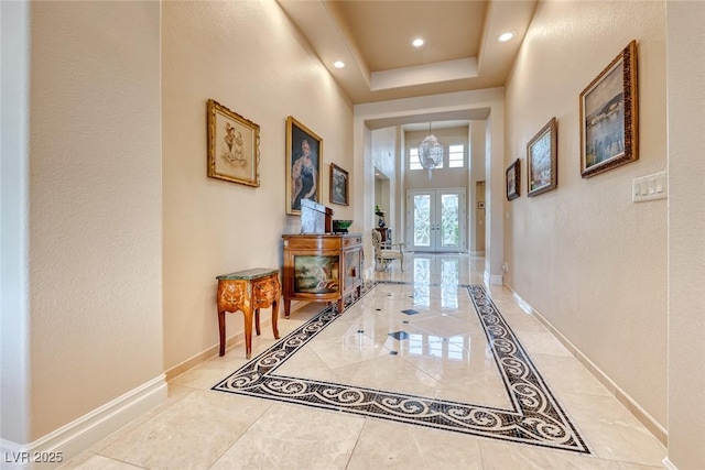 doorway with a tray ceiling, french doors, recessed lighting, a towering ceiling, and baseboards