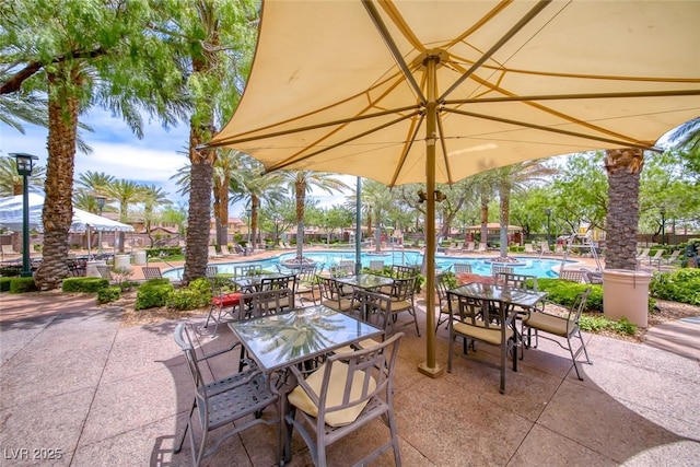 view of patio featuring a community pool and outdoor dining space