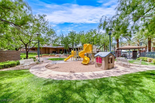 community play area featuring fence and a lawn