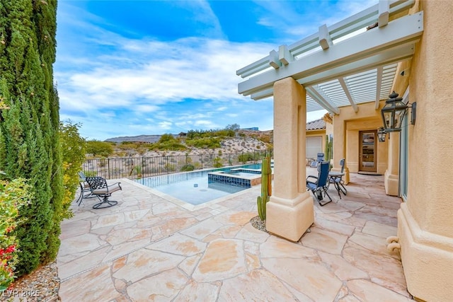 view of pool with a patio, fence, a pool with connected hot tub, a mountain view, and a pergola