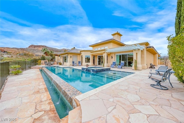 view of swimming pool featuring a mountain view, a patio, fence, and a pool with connected hot tub