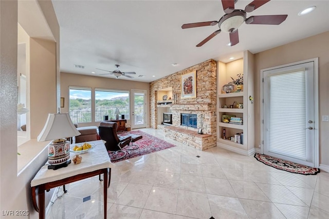 tiled living area featuring visible vents, built in features, baseboards, a stone fireplace, and recessed lighting