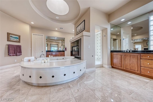 full bath with recessed lighting, a garden tub, visible vents, and baseboards