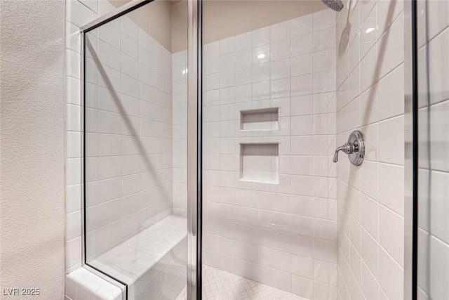 full bathroom with a shower stall and a textured wall