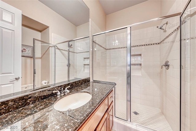 bathroom with a stall shower and vanity