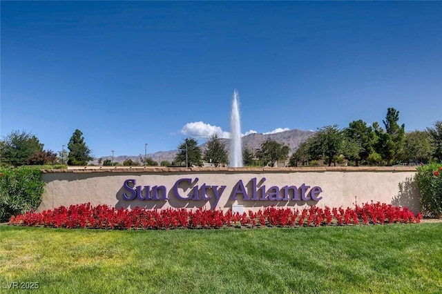 community / neighborhood sign featuring a yard and a mountain view