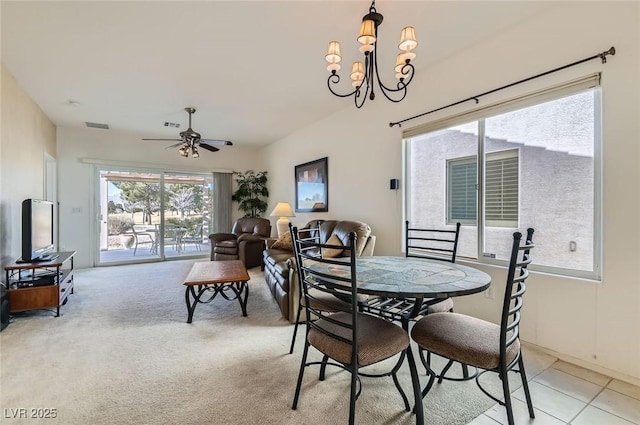 dining room with light carpet, ceiling fan with notable chandelier, and visible vents