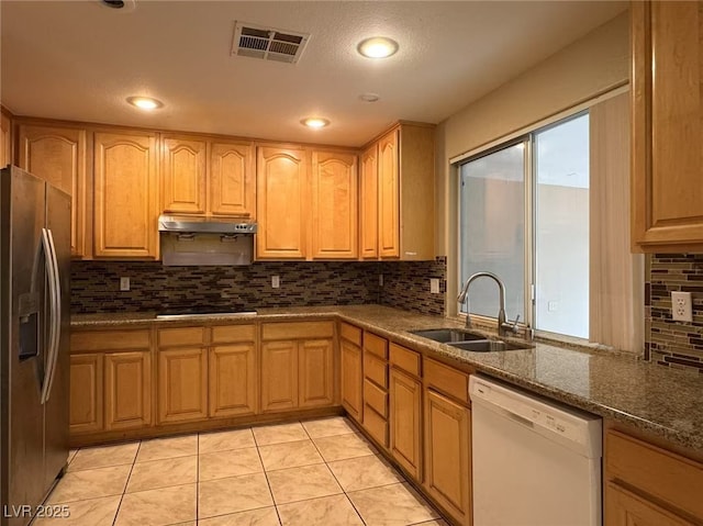 kitchen with visible vents, a sink, stainless steel fridge, dishwasher, and under cabinet range hood