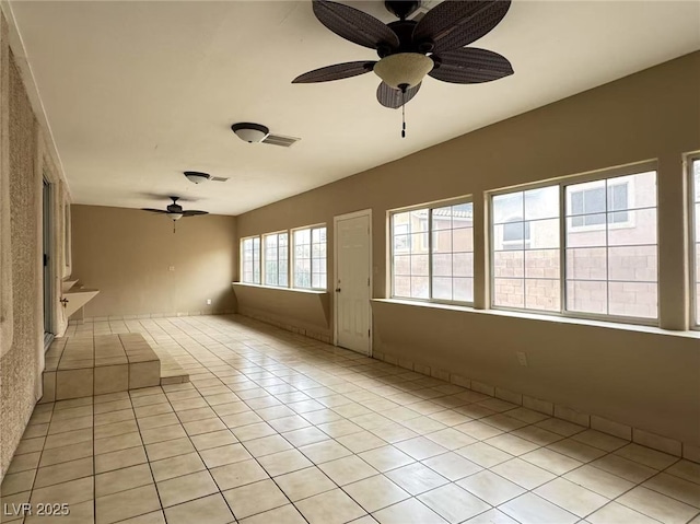 empty room with a ceiling fan, visible vents, and light tile patterned floors