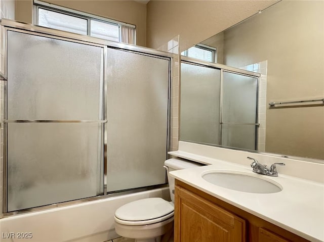 full bath with shower / bath combination with glass door, vanity, and toilet