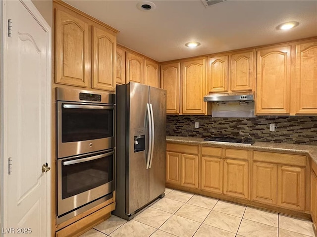 kitchen with under cabinet range hood, appliances with stainless steel finishes, backsplash, and light tile patterned flooring