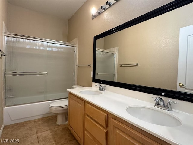 bathroom featuring double vanity, tile patterned flooring, a sink, and toilet