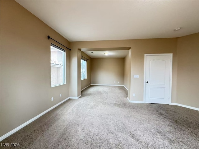 carpeted spare room featuring baseboards