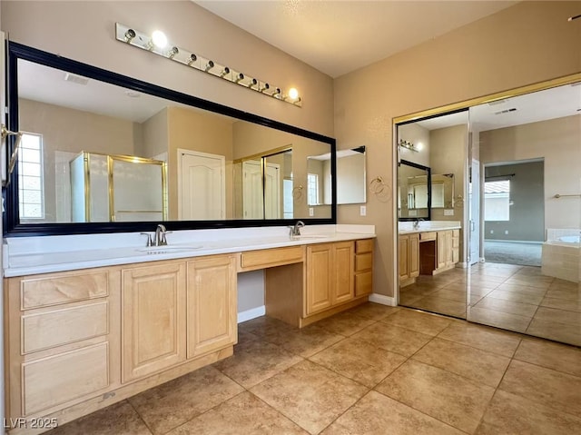 full bath with double vanity, a stall shower, baseboards, tile patterned flooring, and a sink