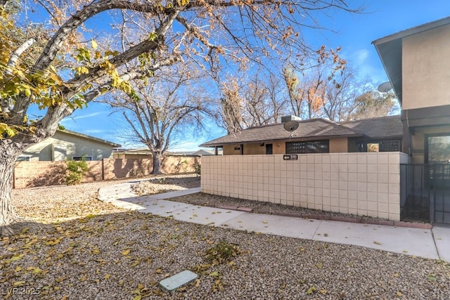 view of side of property featuring a fenced front yard and stucco siding