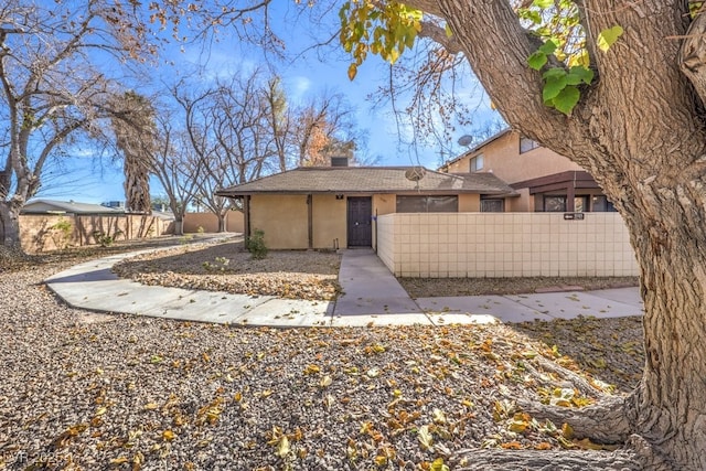 view of front of home with a fenced front yard and stucco siding